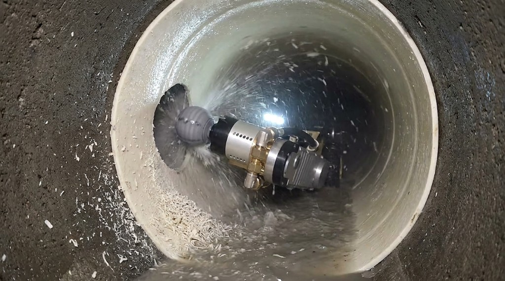 Robotic cutter milling a lateral opening through CIPP liner inside a host sewer